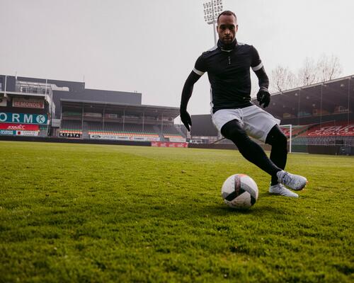 Man dribbling football on the pitch