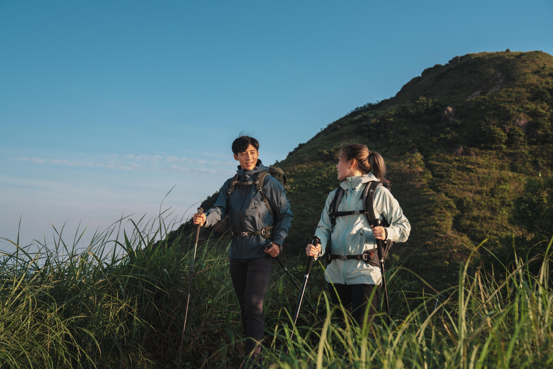 Para na pieszej wycieszcze z kijkami trekkingowymi w rękach