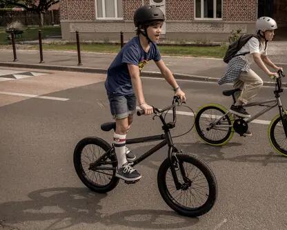 Dzieci w kaskach jadący na rowerach bmx