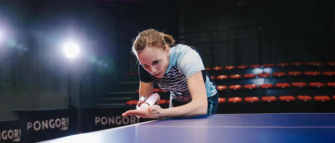 W9oman studying her table tennis paddle