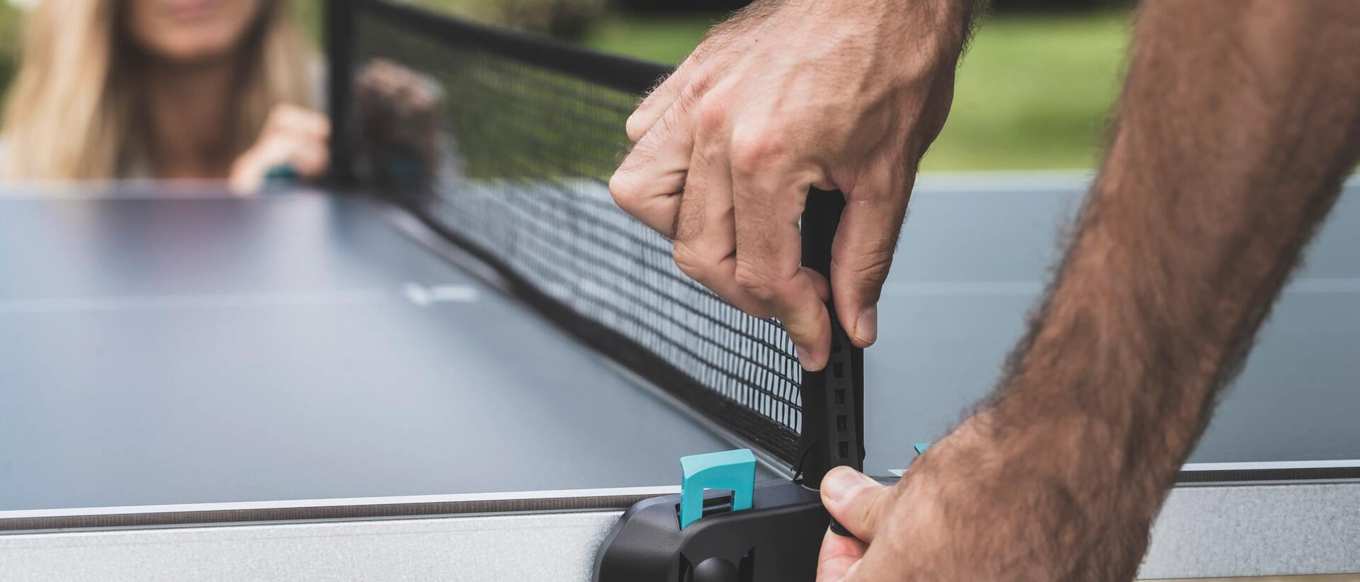 Man setting up net for outdoor table tennis table