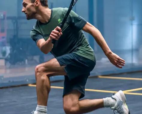 Women about to hit a squash ball with a racket