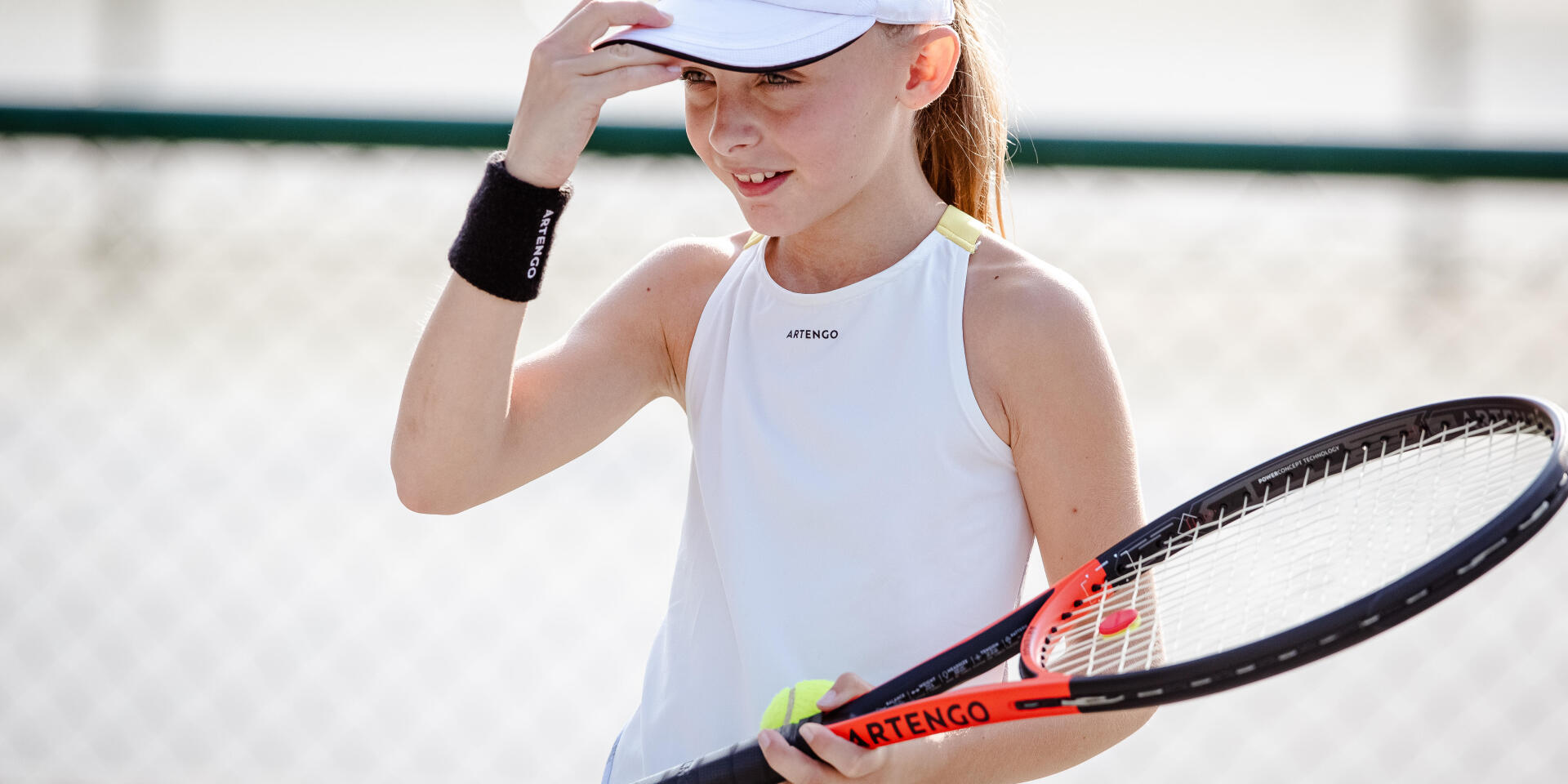 une jeune fille porte une raquette de tennis