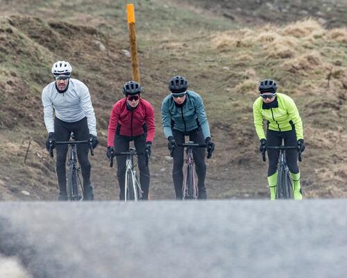 4 people cycling next to each other on the road