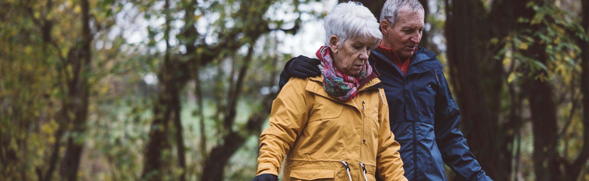 seniorzy w odzieży trekkingowej spacerujący w celu zapobiegania osteoporozie