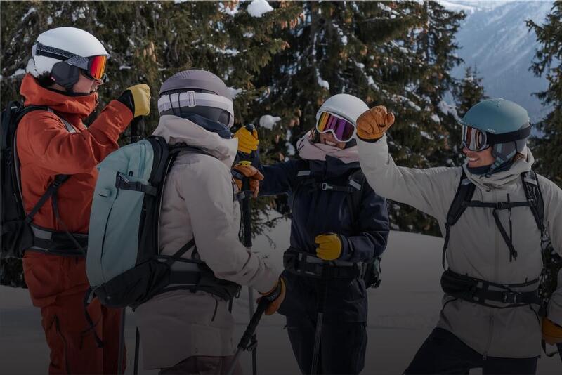 rozmawiający narciarze w kaskach i goglach narciarskich