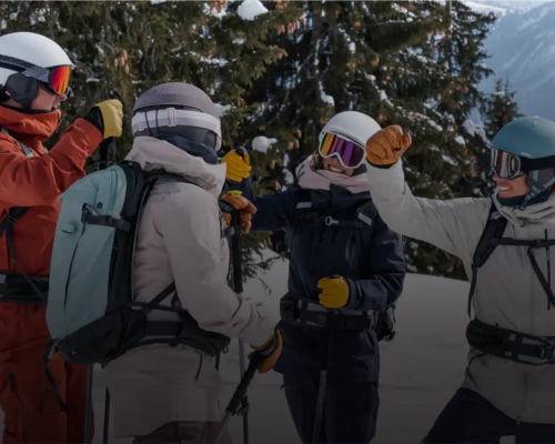 rozmawiający narciarze w kaskach i goglach narciarskich