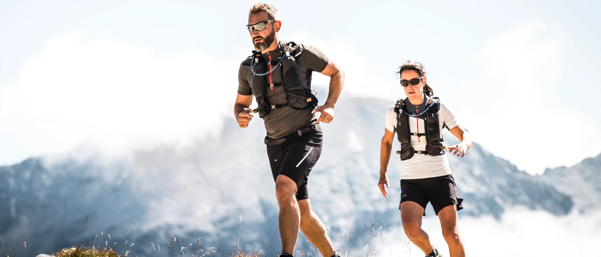 Man and woman trail running in mountains