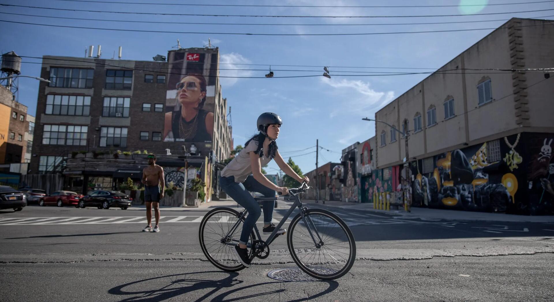 kobieta w kasku rowerowym jadąca na rowerze miejskim