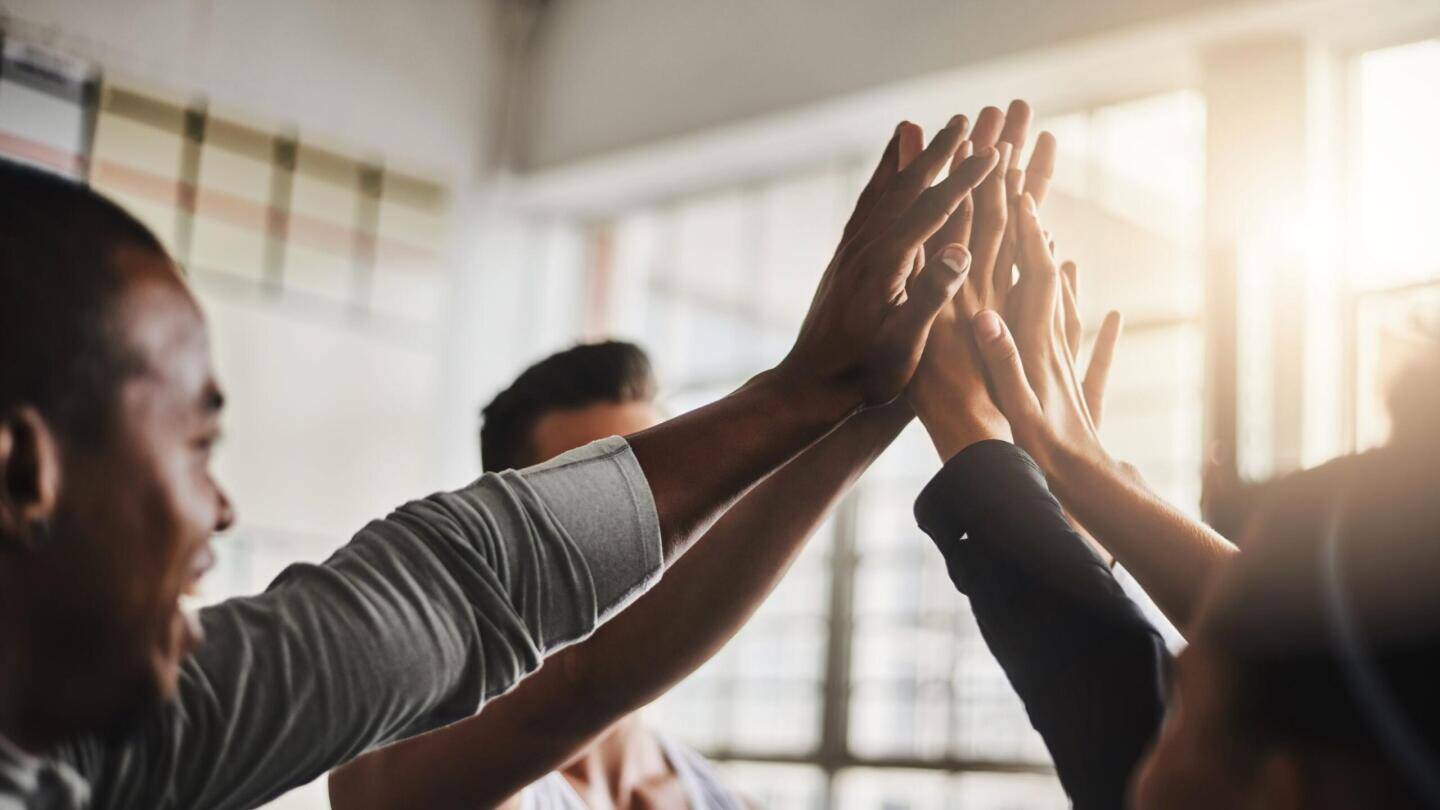 Shot of a group of young people giving each other a high five during their workout in a gym