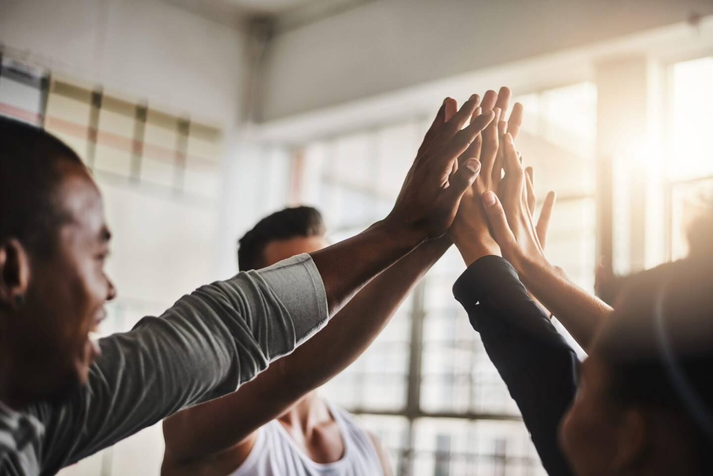 Shot of a group of young people giving each other a high five during their workout in a gym