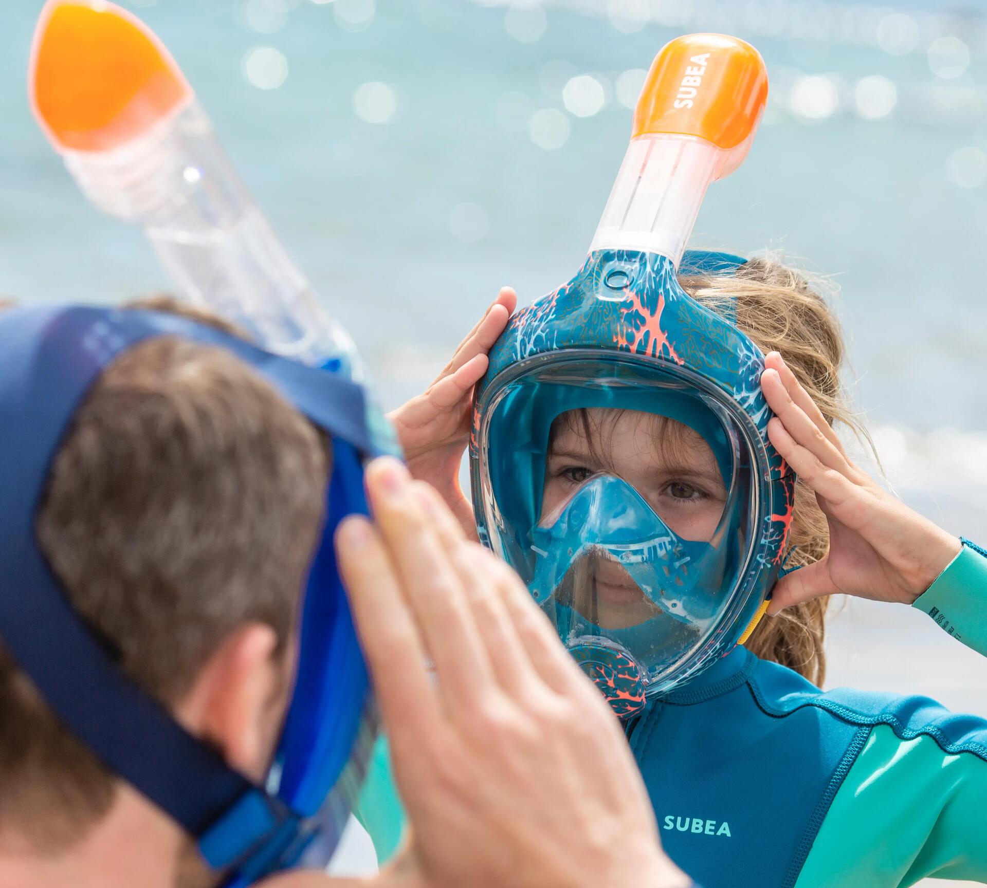 A man and woman adjusting their snorkeling masks
