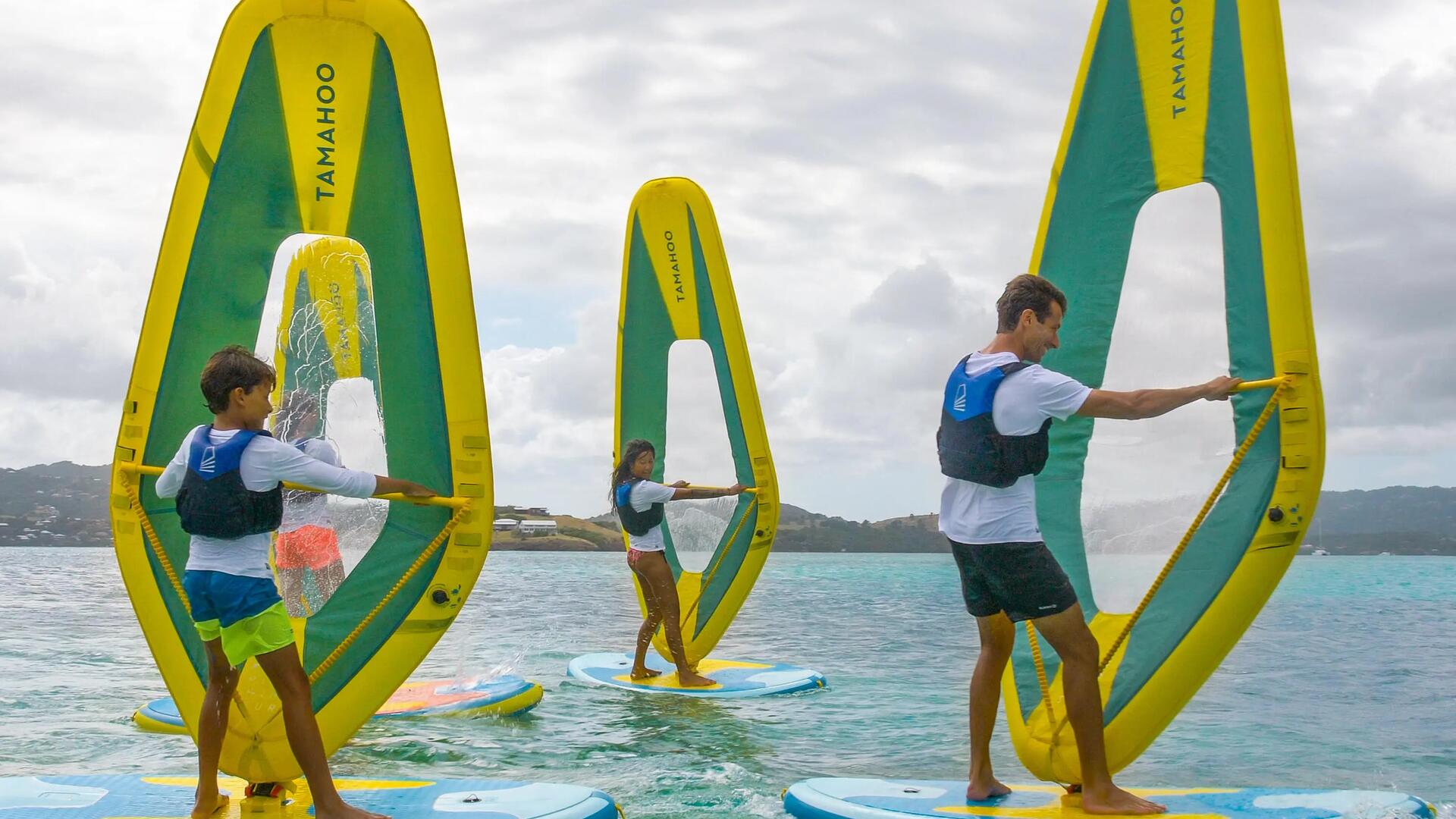 ludzie uczący się pływać na windsurfingu