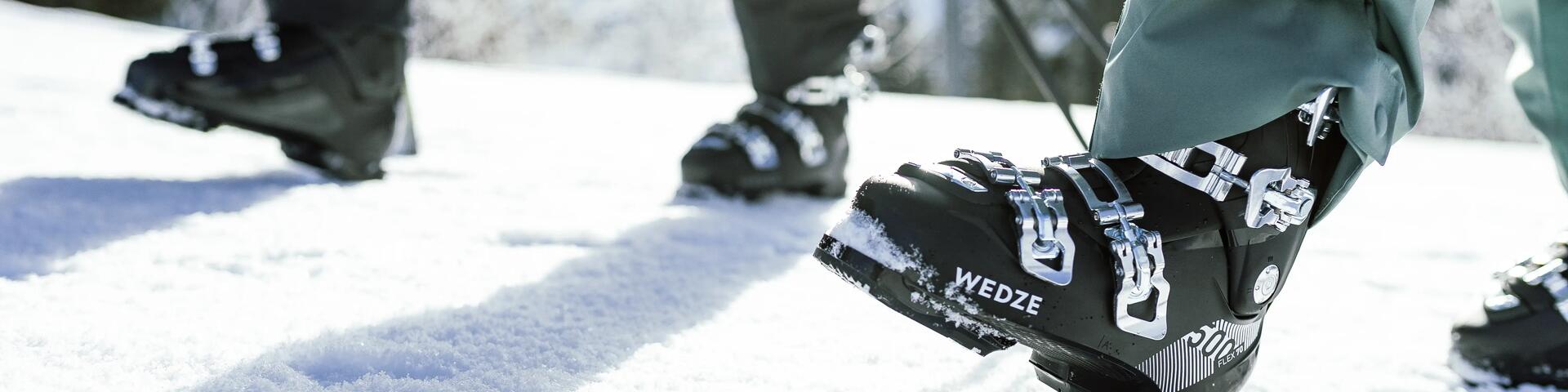 osoby idące w butach narciarskich po śniegu