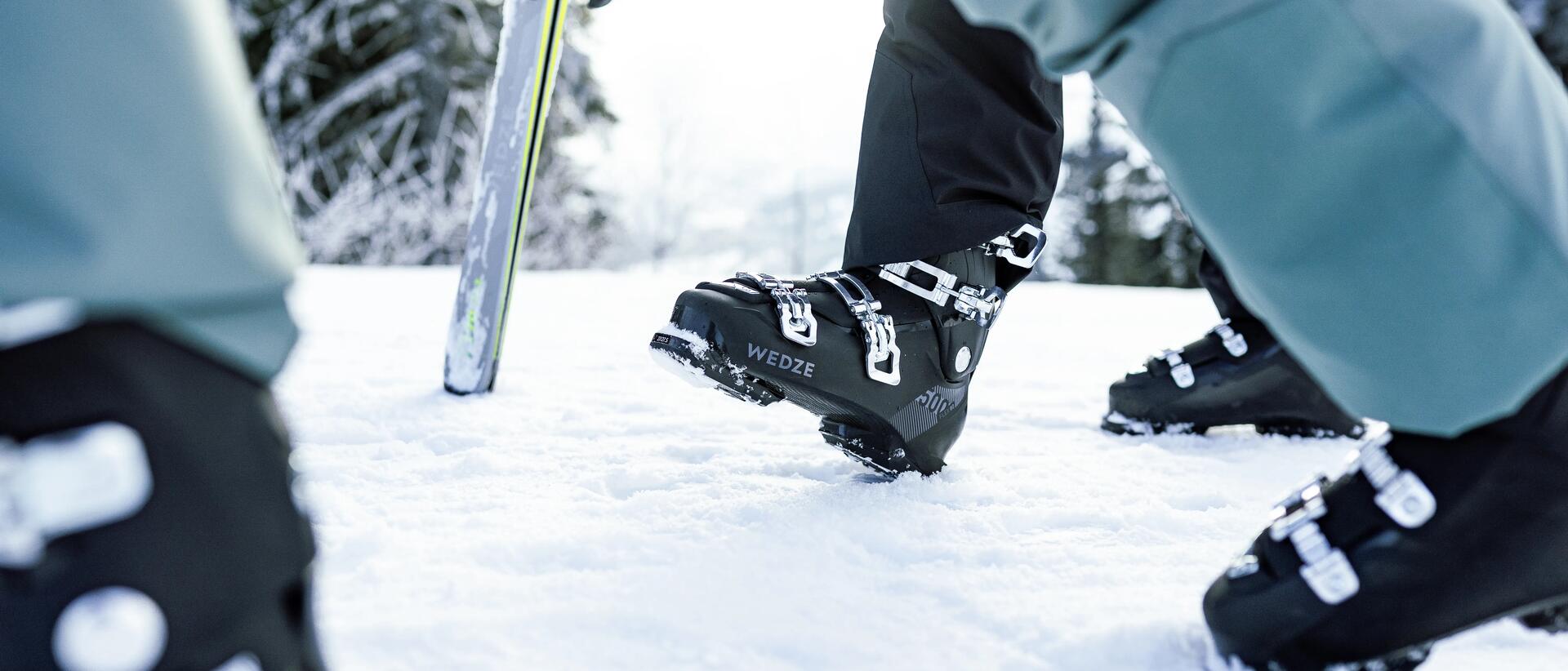 ludzie idący w butach narciarskich po śniegu