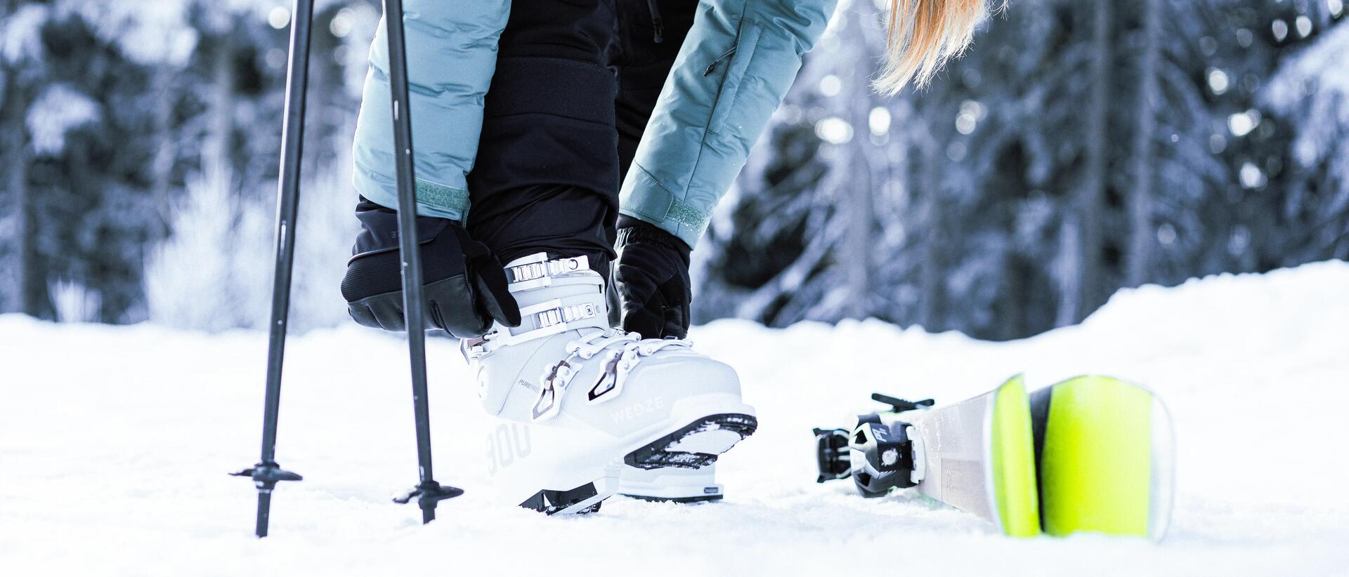 kobieta zapinająca buty narciarskie