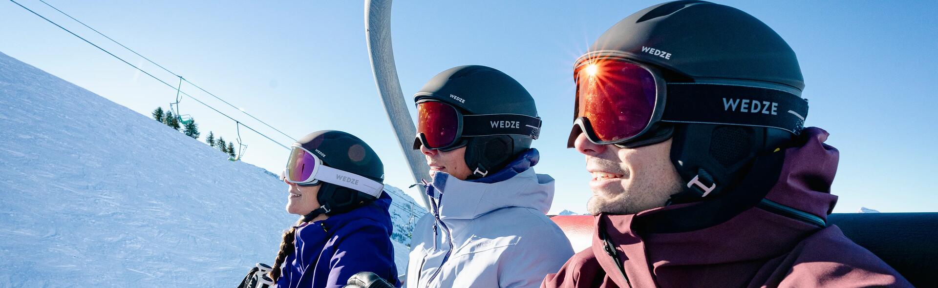 A man and two women wearing ski helmets and goggles.