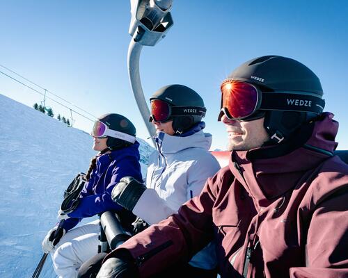 A man and two women wearing ski helmets and goggles.