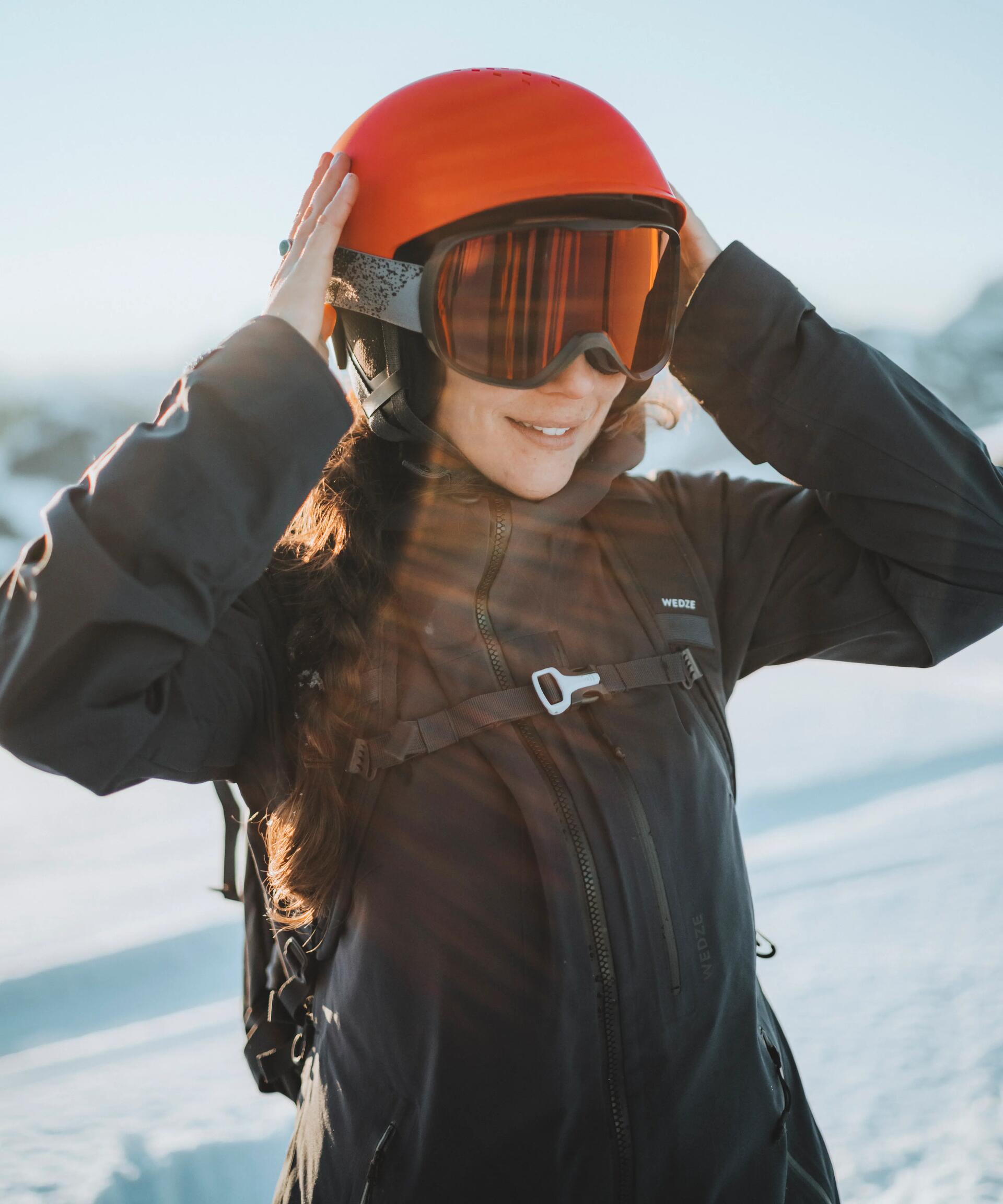 Lady adjusting her ski helmet.