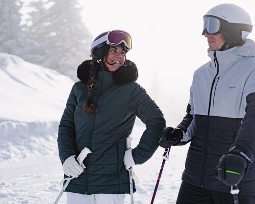 kobieta i mężczyzna w strojach i kaskach narciarskich na śniegu
