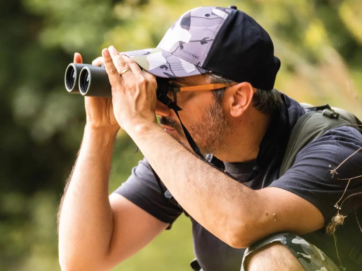 Man looking through binoculars from mountains