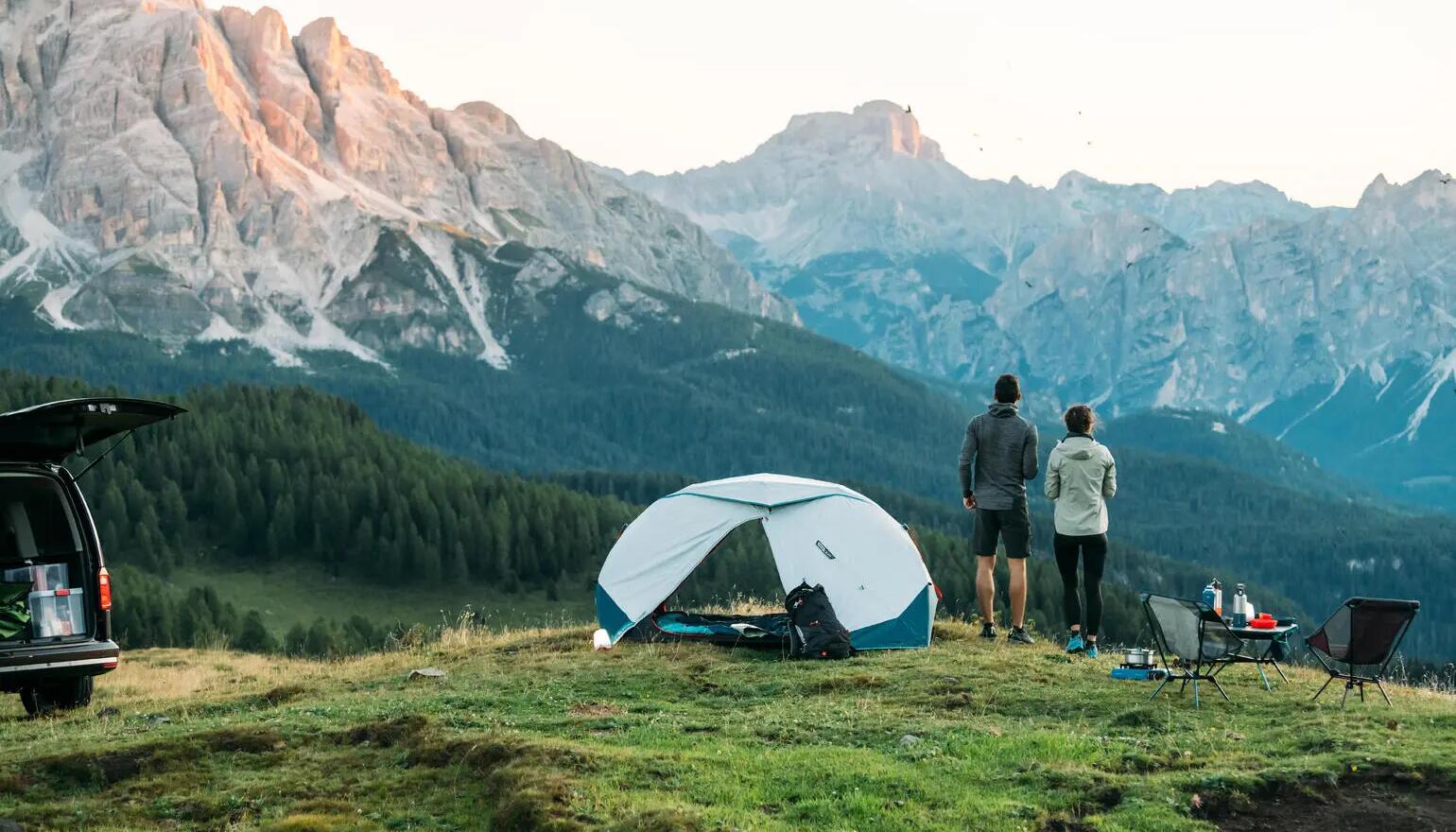 kobieta i mężczyzna stojący przed namiotem w górach