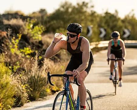 Rowerzyści jadący na rowerach w zawodach triathlonowych