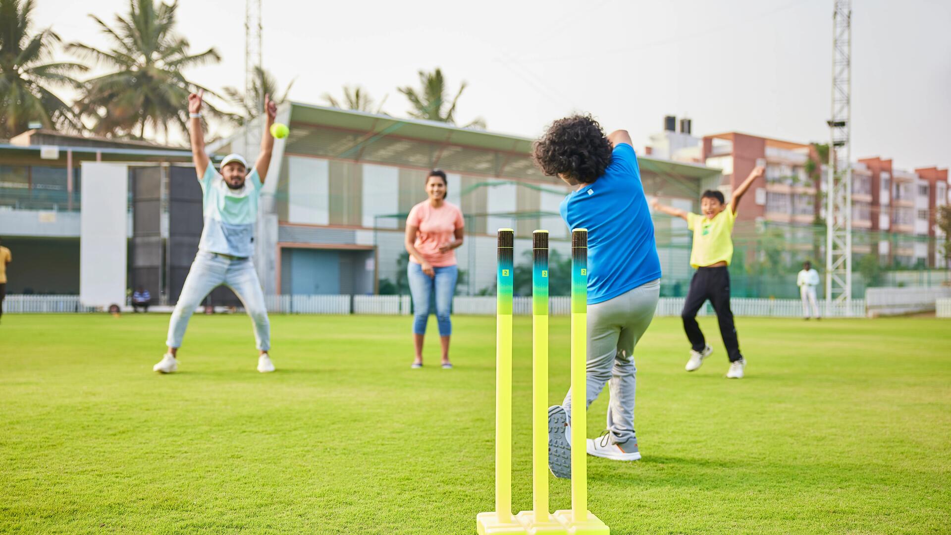 a family playing with a cricket set in the park