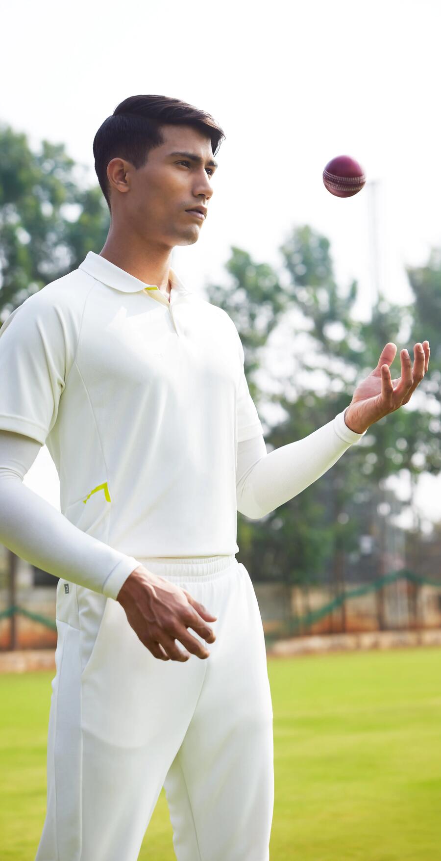 man throwing a cricket ball in the air