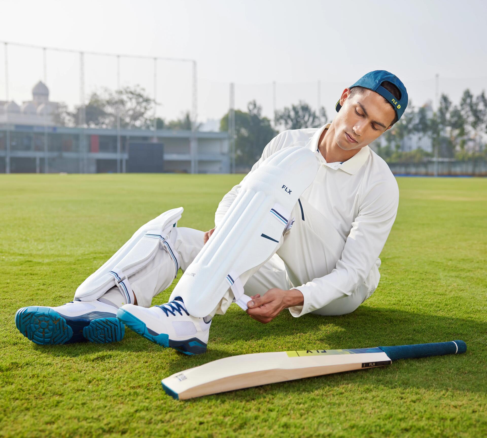 man adjusting his cricket pads