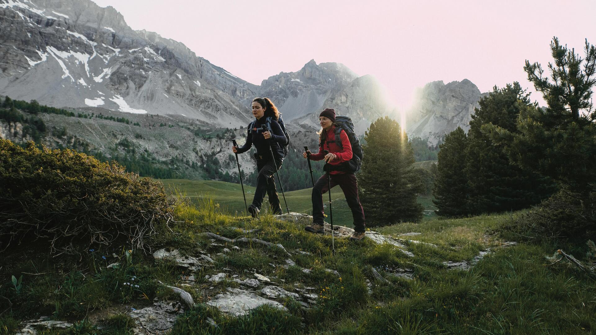 kobiety wędrujące po górach w odzieży trekkingowej  z kijami trekkingowymi w rękach