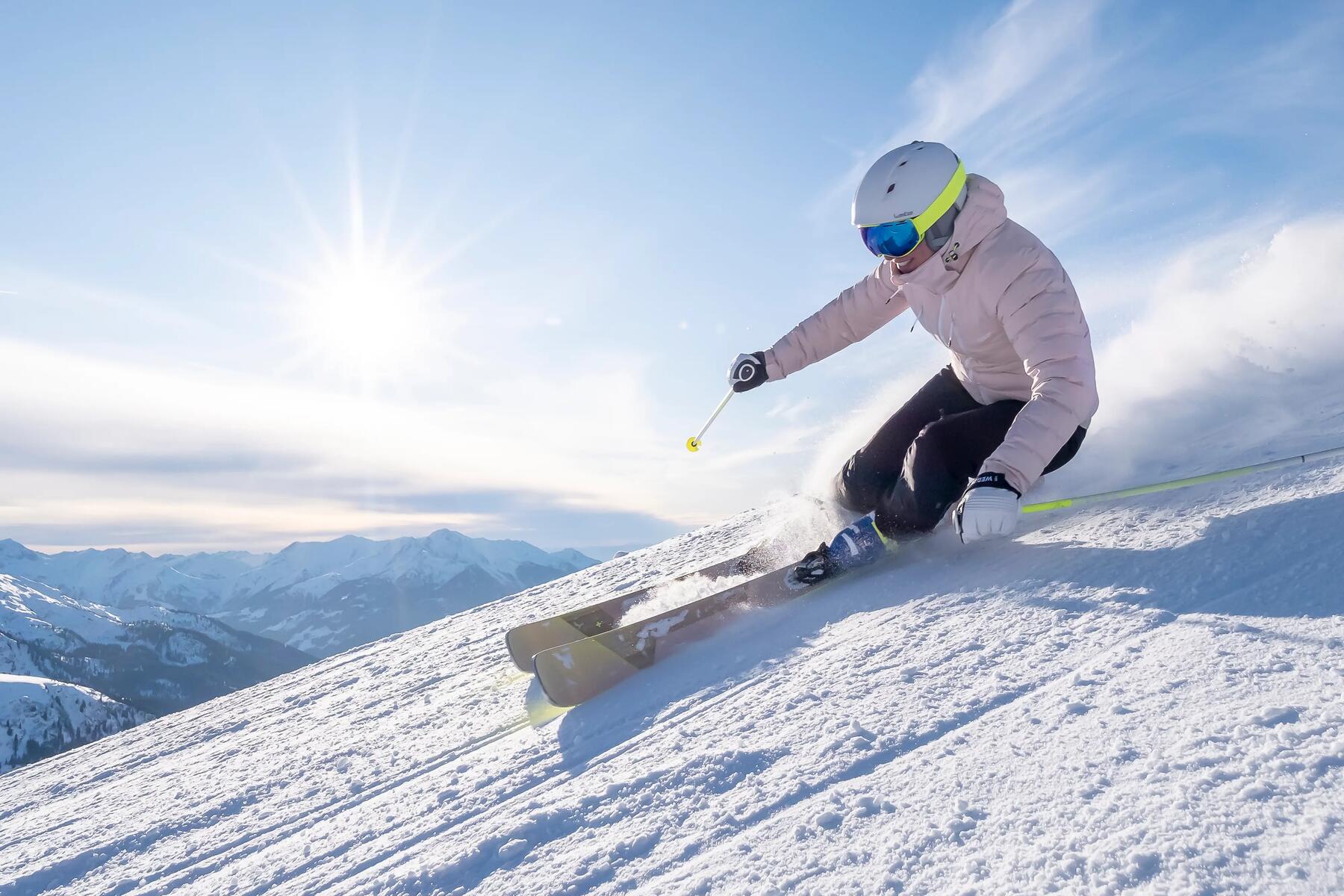 kobieta zjeżdża na nartach w odzieży narciarskiej