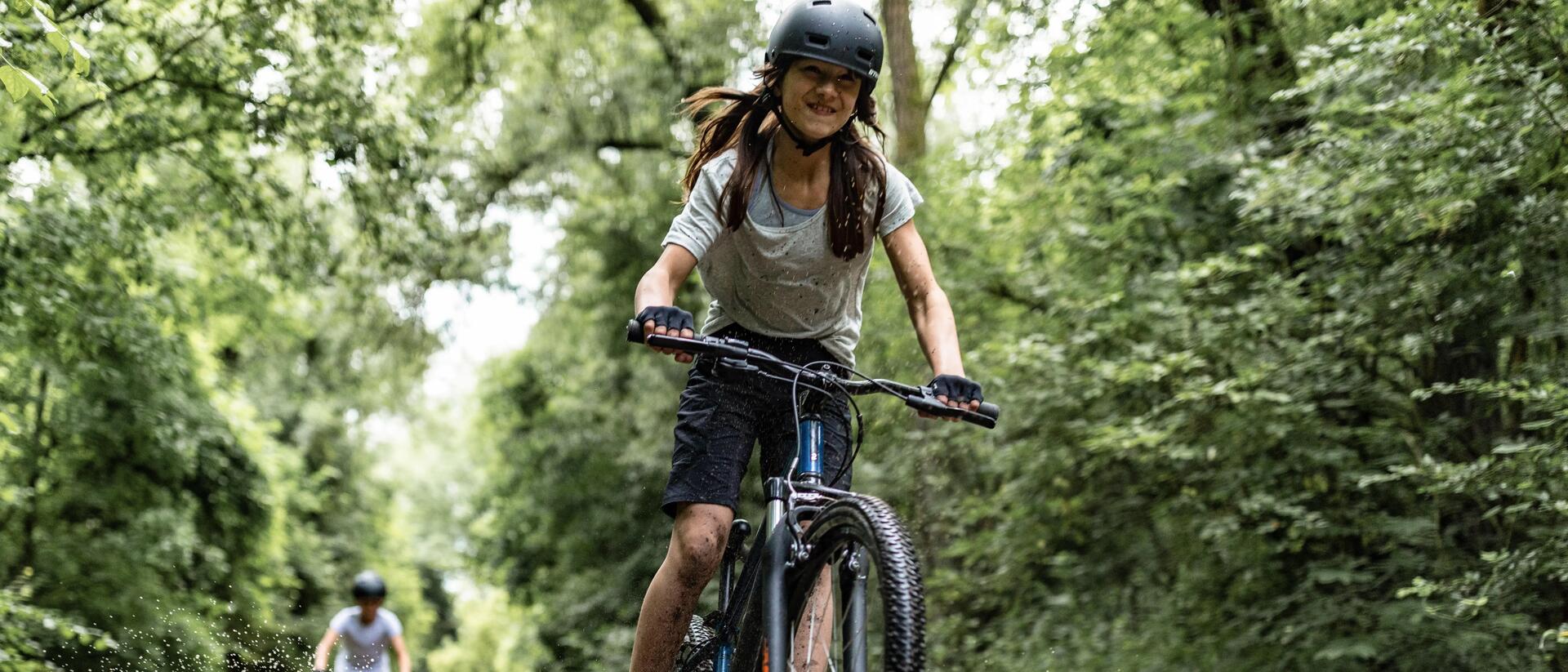 dziewczynka w kasku jadąca na rowerze górskim