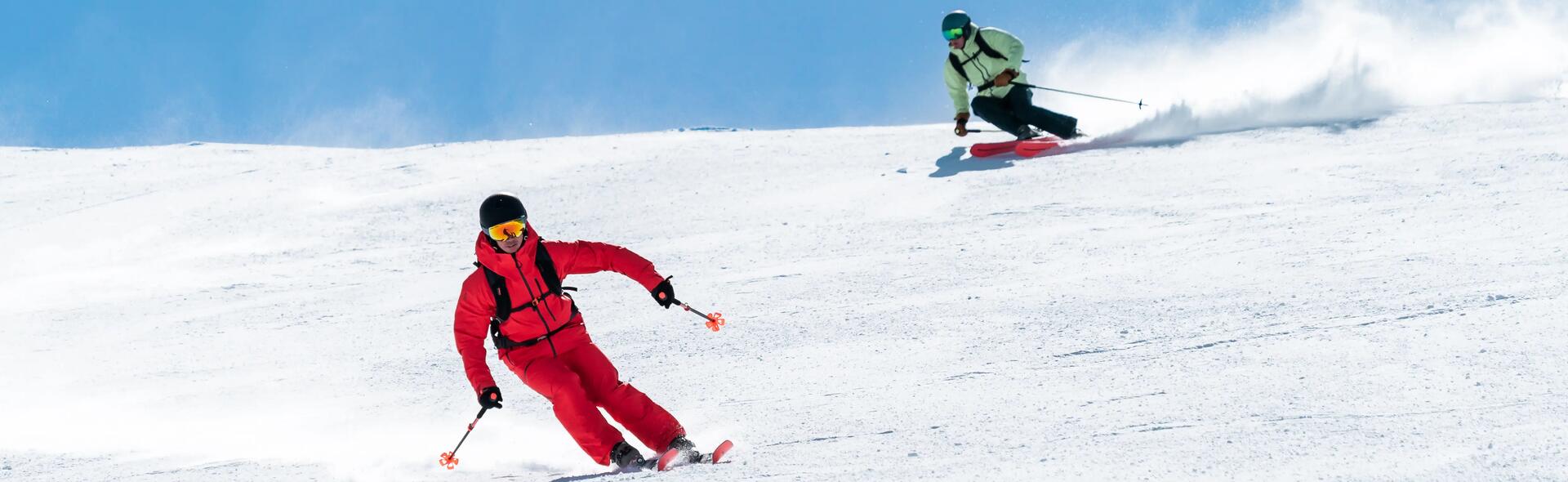 2 osoby trenujące narciarstwo zjazdowe na stoku