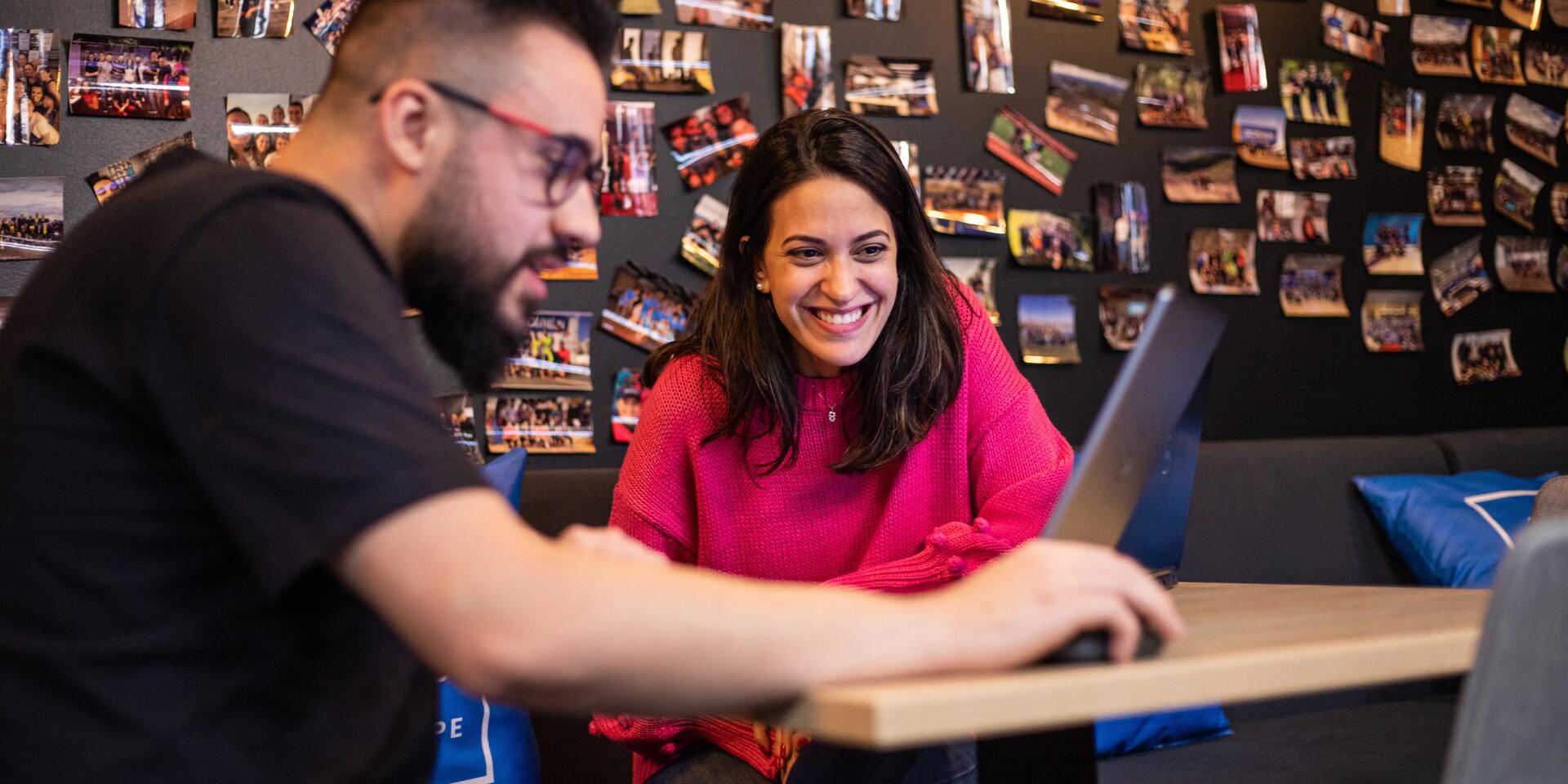 Man and woman looking at laptop and smiling