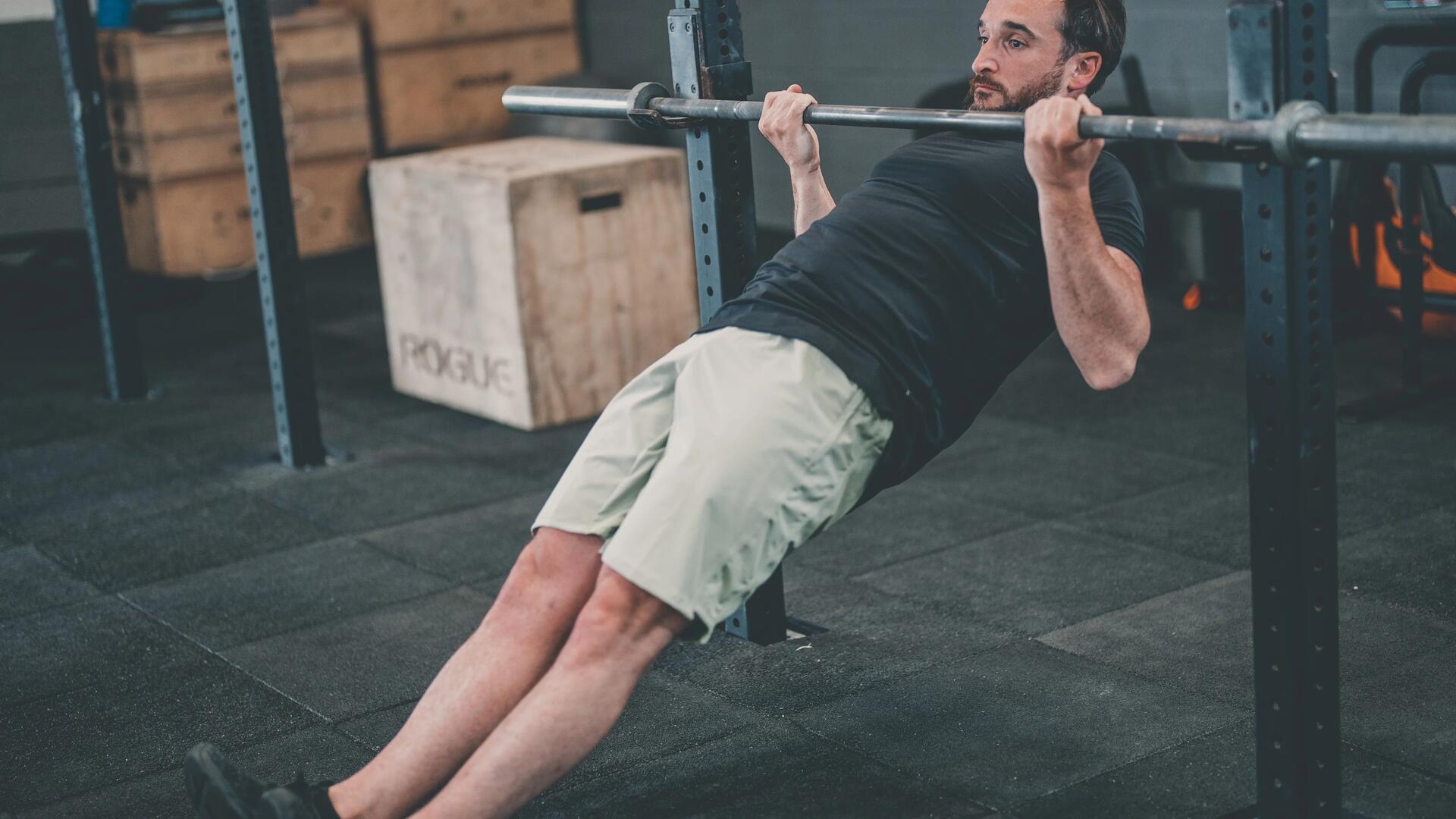 mężczyzna w stroju sportowym wykonujący podchwyt na drążku do podciągania