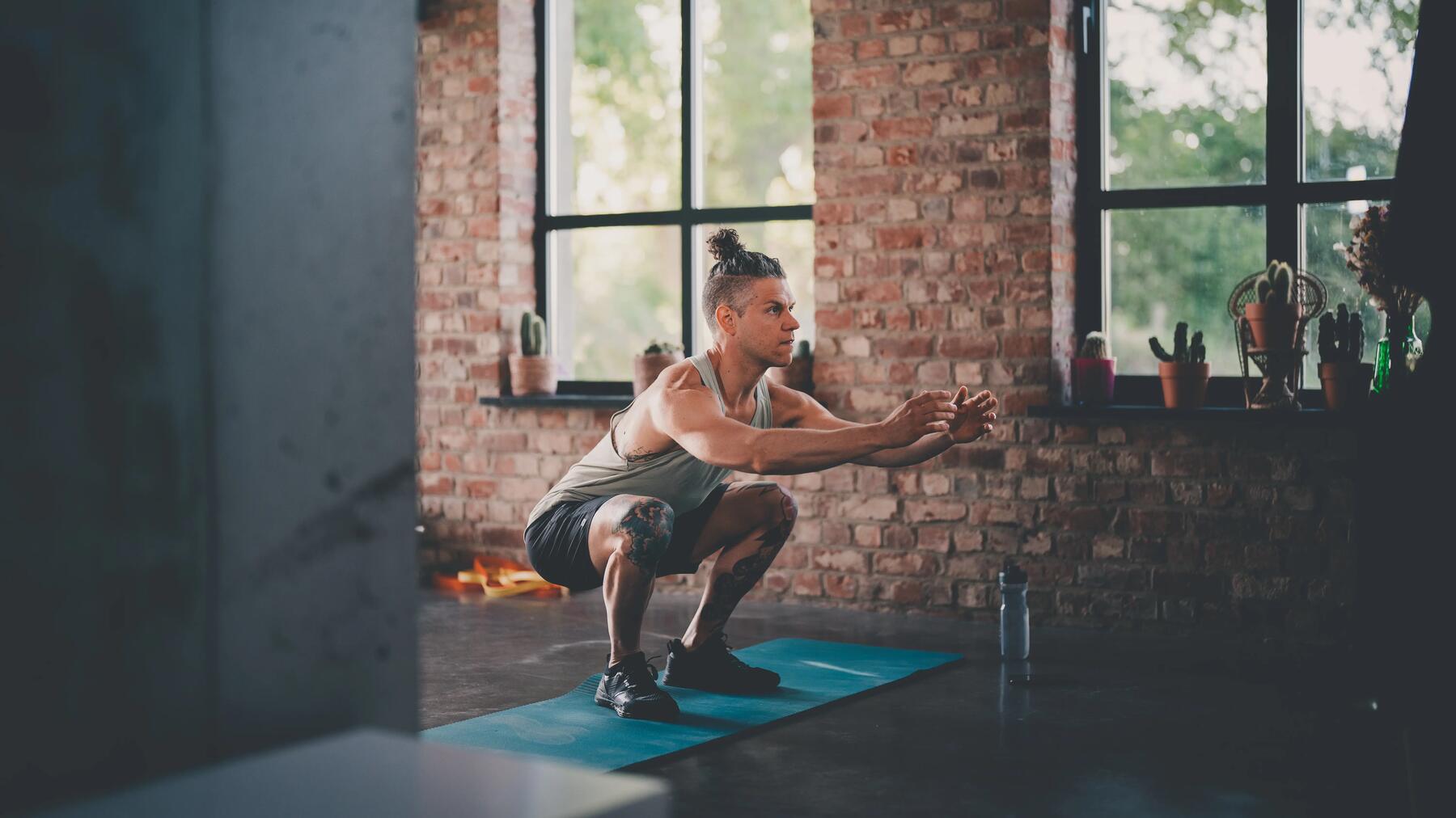 hombre haciendo ejercicio de sentadilla con salto