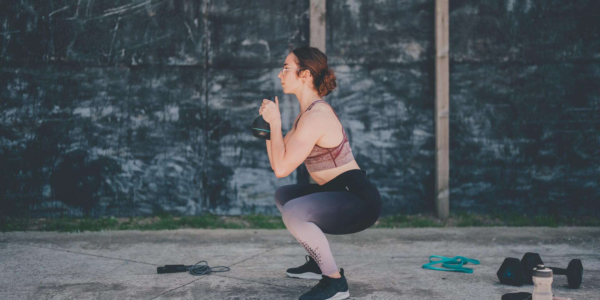 kobieta wykonująca przysiady z kettlebell