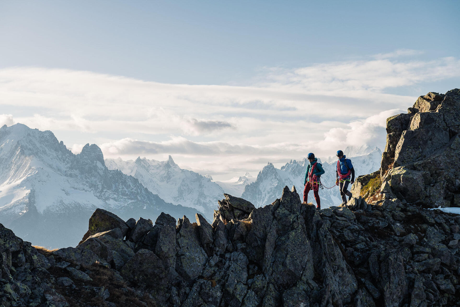 Alpiniści wędrujący po szczytach gór z uprzężami w stylu alpejskim