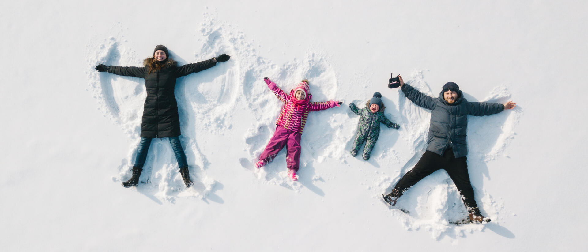 kobieta i mężczyzna z dziećmi leżą na śniegu