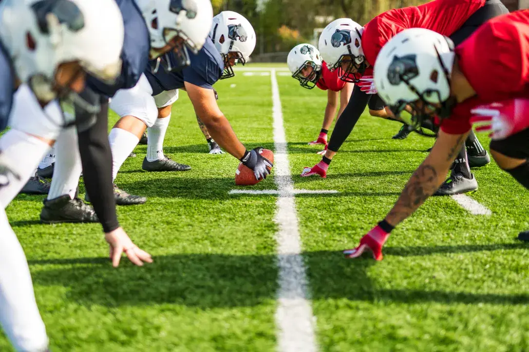 Zwei Teams schauen sich gegenseitig an, bevor das American football Match los geht.