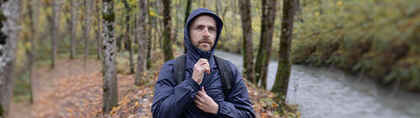 Man in rain jacket walking in woods