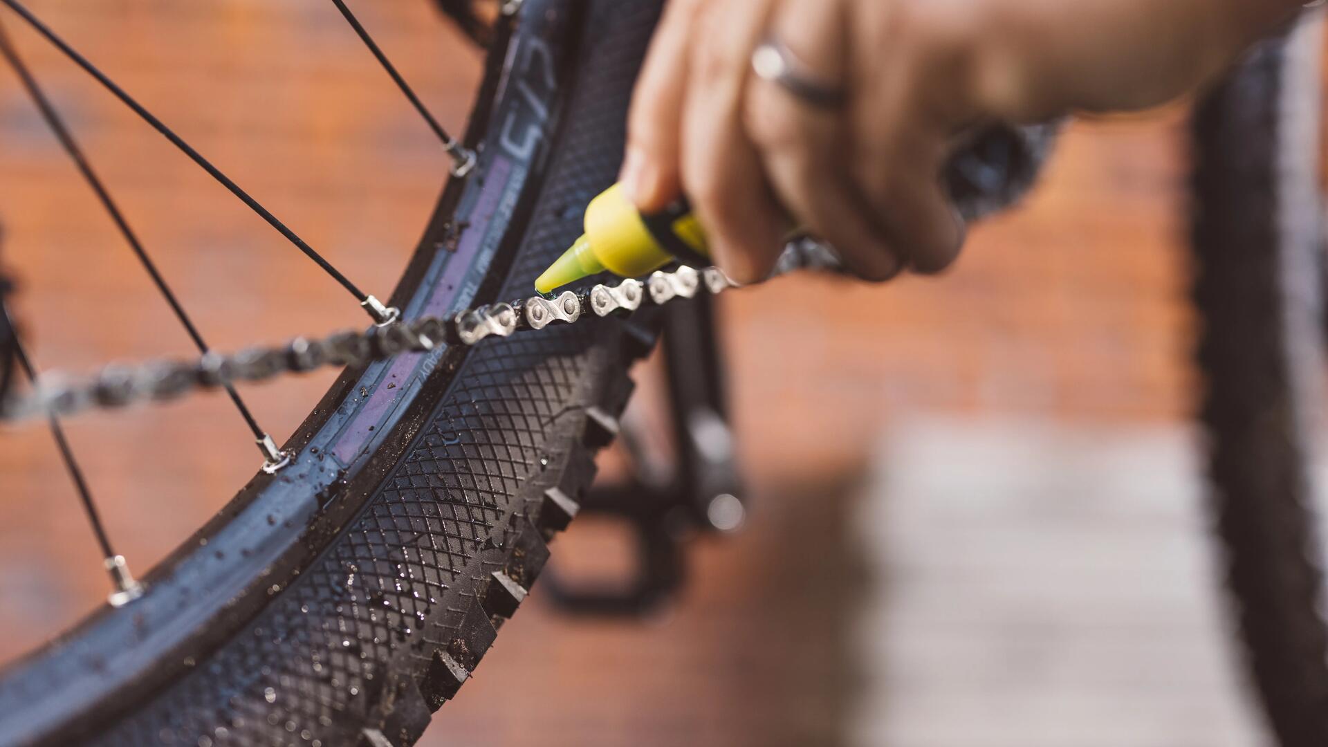 pessoa a colocar oleo na corrente da bicicleta