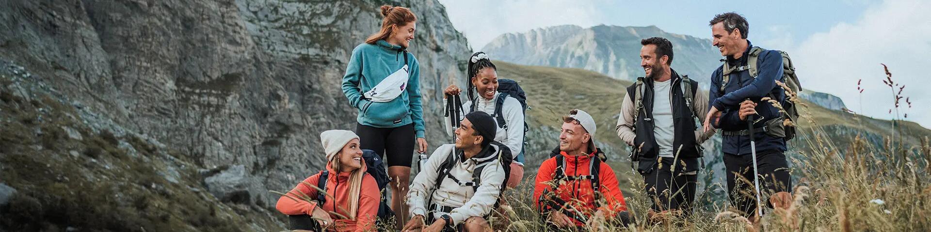 A group of friends hiking on a grassy mountain trail.