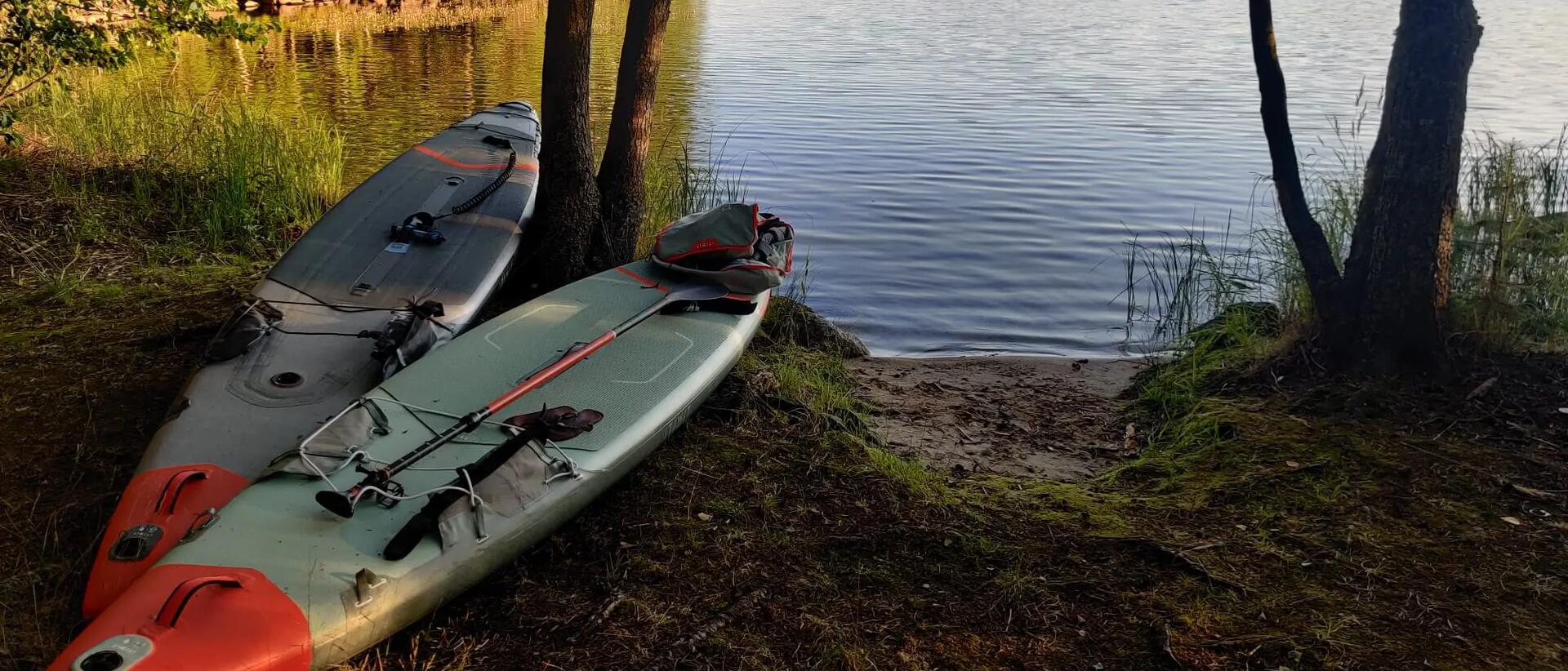 sztywne kajaki leżące nad wodą