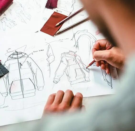 Someone sketching designs of a hoodie.