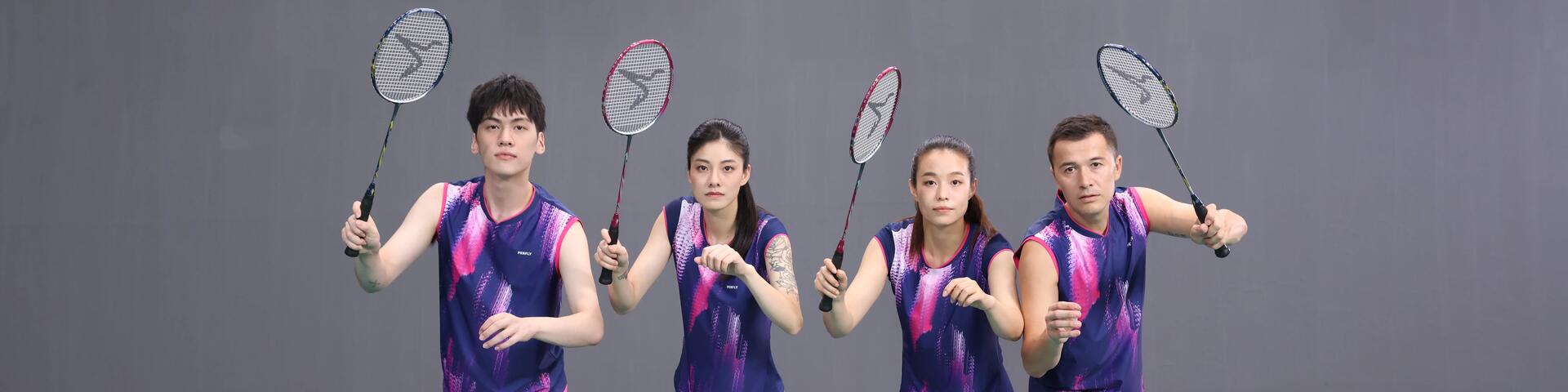 zawodnicy trzymający w rękach uniesione rakiety do badmintona