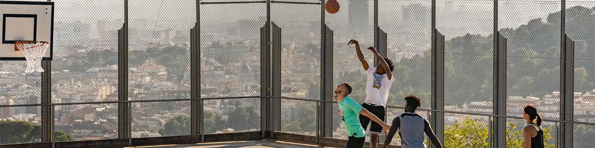 kobieta i mężczyźni grający piłką do koszykówki na boisku