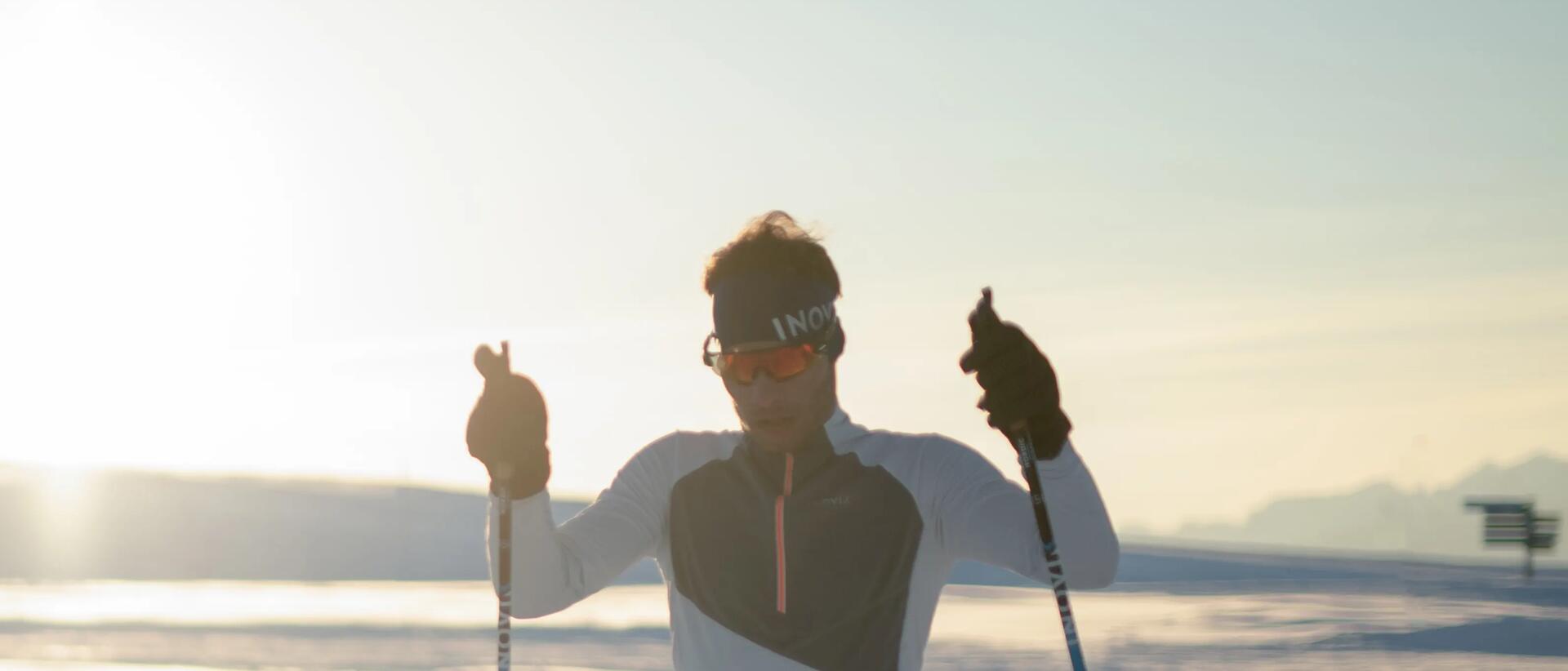 mężczyzna na nartach biegowych trzymający kijki