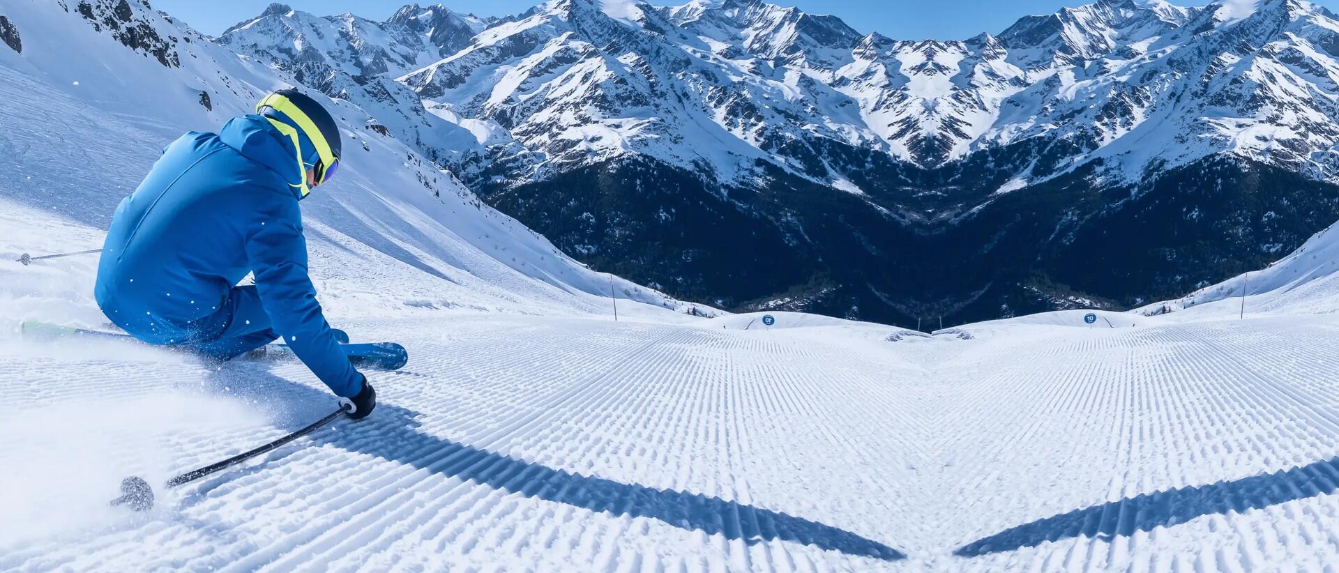 mężczyzna zjeżdżający ze stoku na nartach w kasku i goglach narciarskich